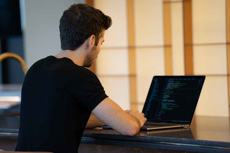 graphic of a programmer working on a laptop