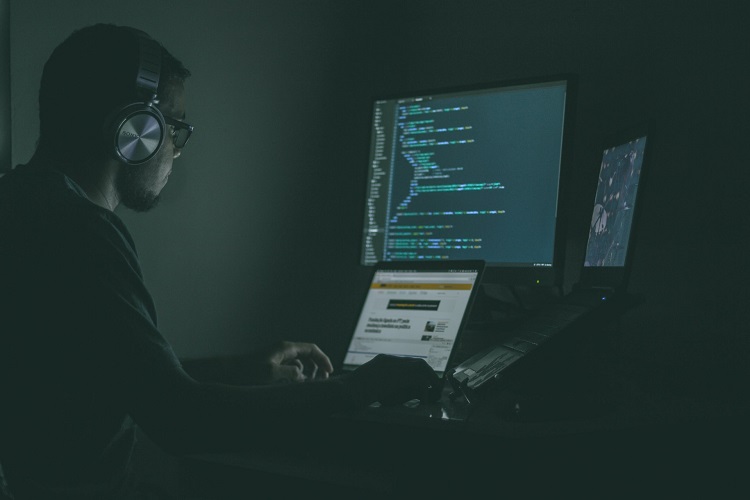 a hired programmer working on a laptop at a startup